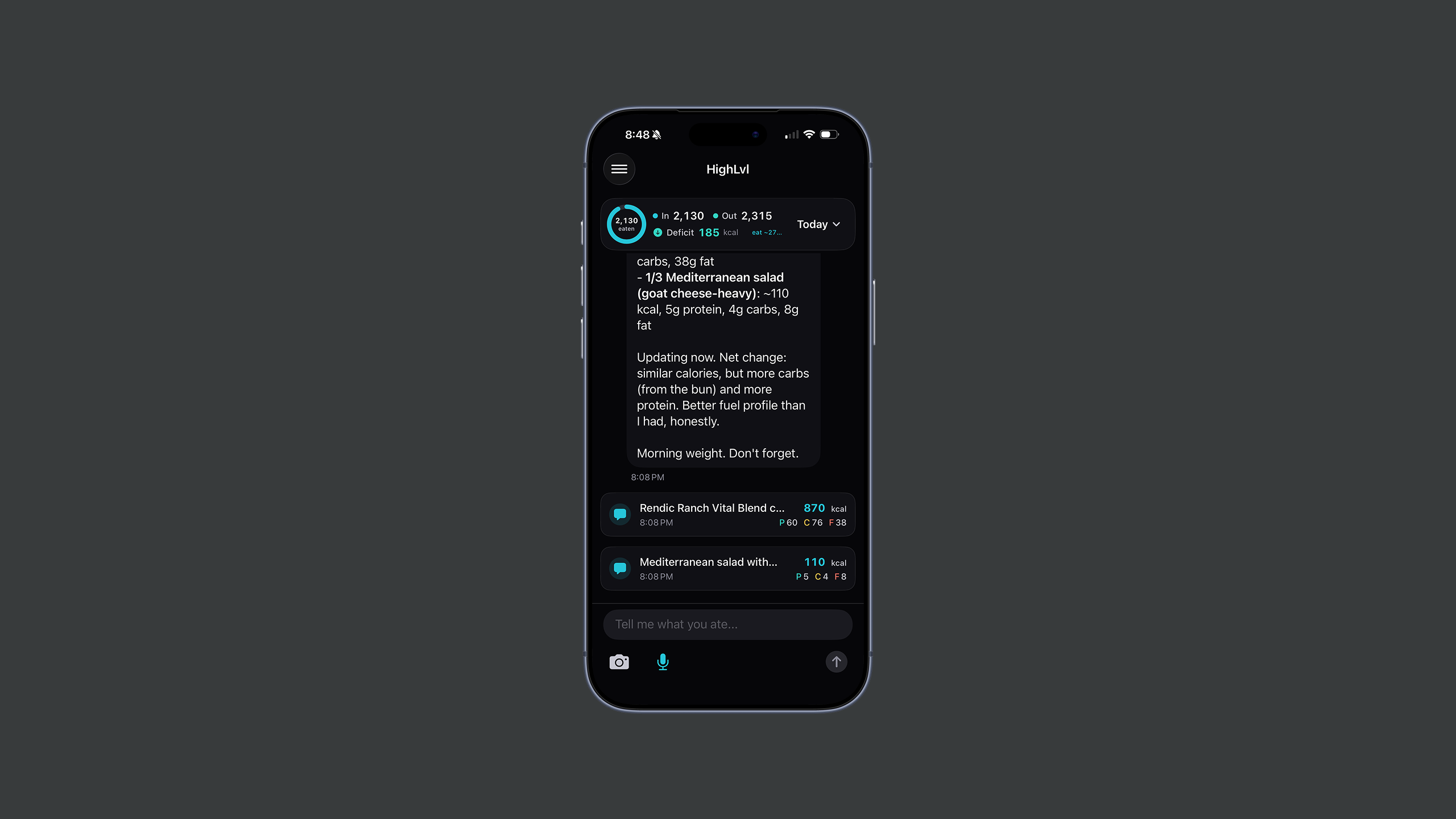 The HighLvl coach view on iPhone — an In 2,130 / Out 2,315 / Deficit 185 kcal summary at the top, a coach message breaking down a logged Mediterranean salad and a "Morning weight. Don't forget." nudge, logged-food cards with calorie and macro counts, and a "Tell me what you ate…" input with camera and mic.