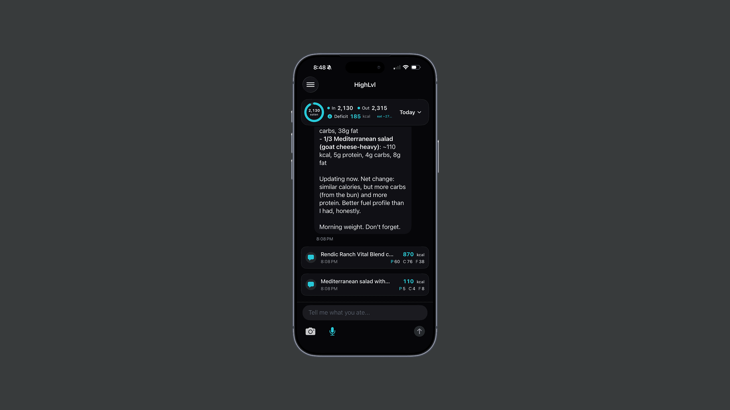 The HighLvl coach view on iPhone — an In 2,130 / Out 2,315 / Deficit 185 kcal summary at the top, a coach message breaking down a logged Mediterranean salad and a "Morning weight. Don't forget." nudge, logged-food cards with calorie and macro counts, and a "Tell me what you ate…" input with camera and mic.